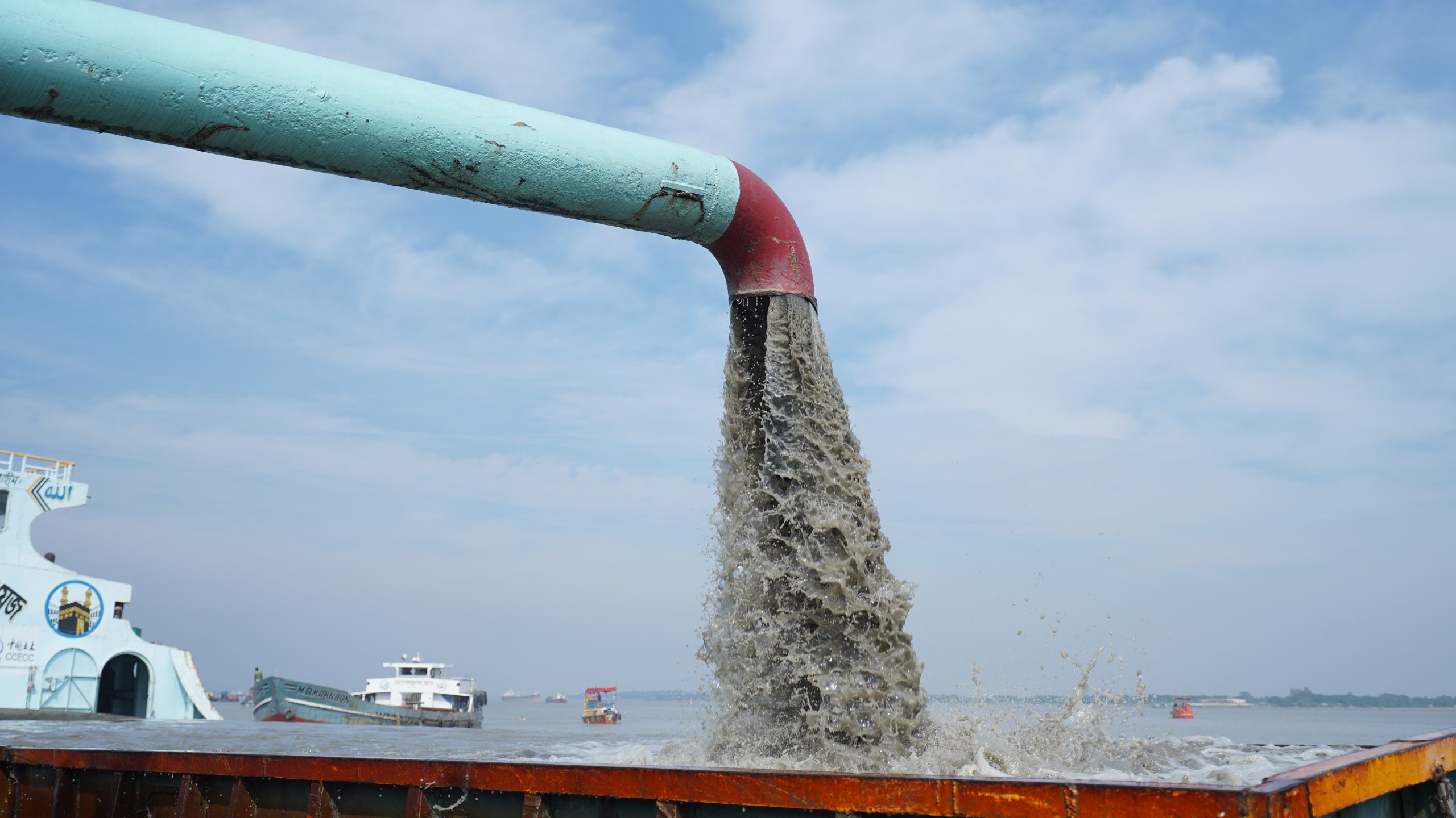 Environmentally sensitive dredging operation near riverbank to reduce erosion and flooding risk.